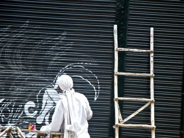 man standing beside brown wooden ladder